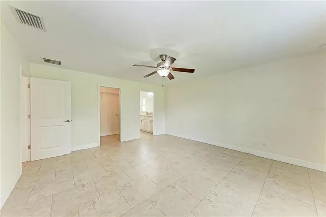 an empty room with a ceiling fan and a window