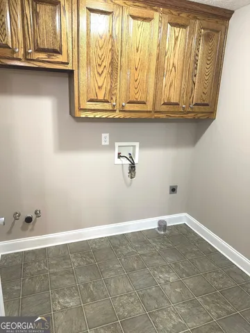 an empty room with windows and chandelier fan