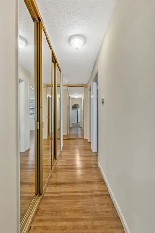 a view of a hallway with wooden floor and staircase
