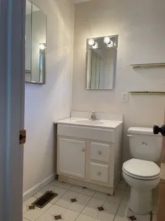 a bathroom with a toilet sink and mirror