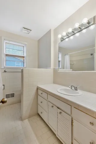 a bathroom with a sink a large mirror and vanity