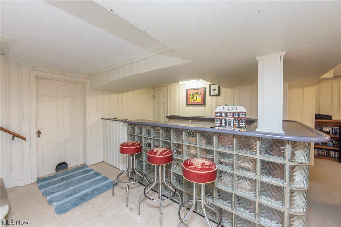 2525 Warwick Road Cleveland, OH 44120 - Photo 18 of 22 Bar with light colored carpet, ornate columns, and white cabinets