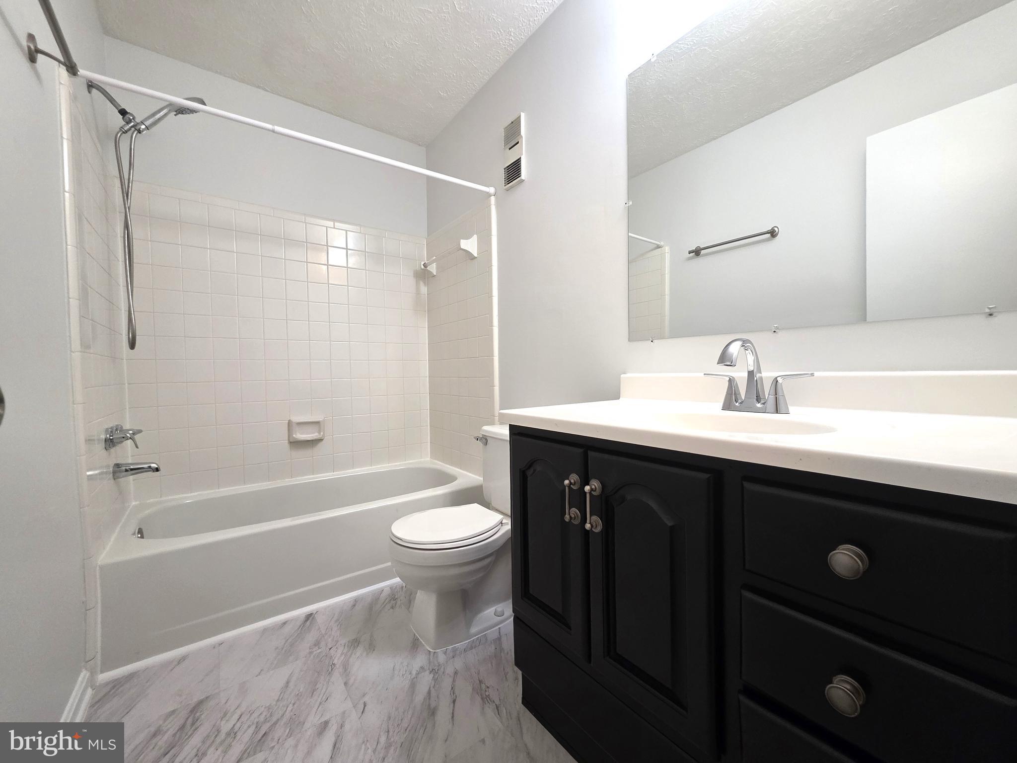 58 Windbrooke Circle, Unit 58 Gaithersburg, MD 20879 - Photo 13 of 28 a bathroom with a sink a toilet a mirror and shower