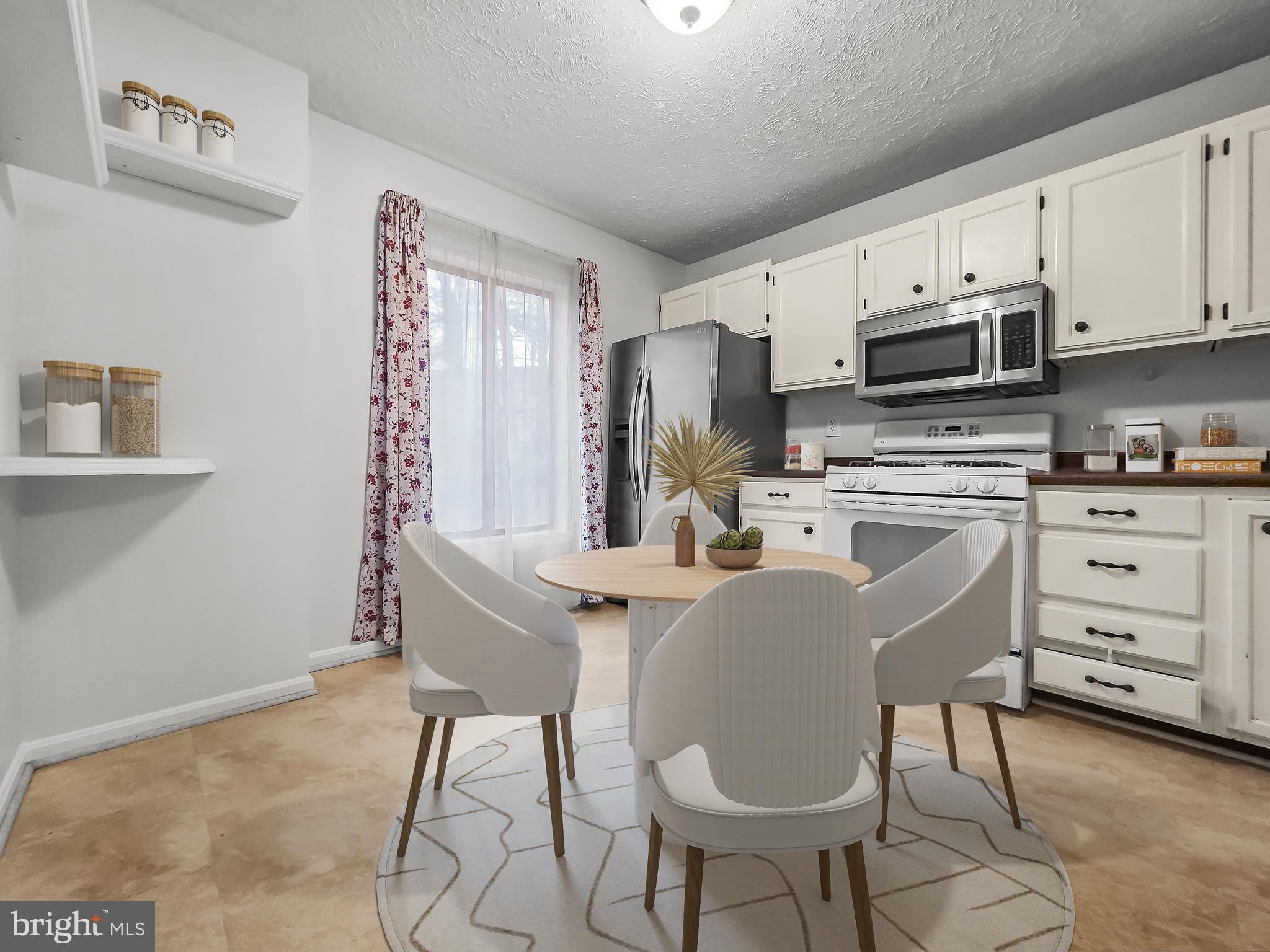 58 Windbrooke Circle, Unit 58 Gaithersburg, MD 20879 - Photo 7 of 28 a kitchen with stainless steel appliances a stove a sink refrigerator and white cabinets with wooden floor