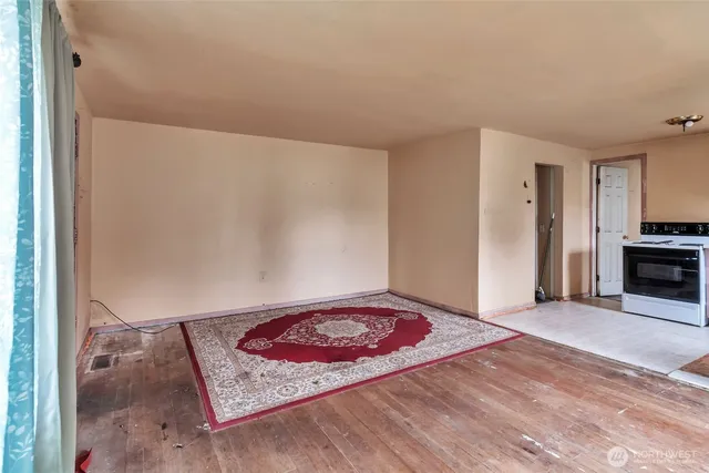 a view of a room with wooden floor and a rug