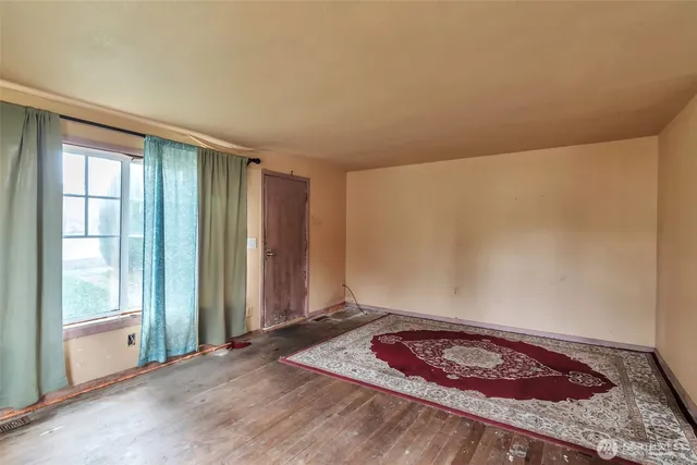 a view of a livingroom with wooden floor and a window