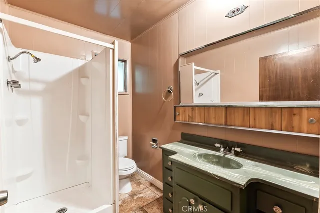 a bathroom with a granite countertop sink mirror vanity and toilet