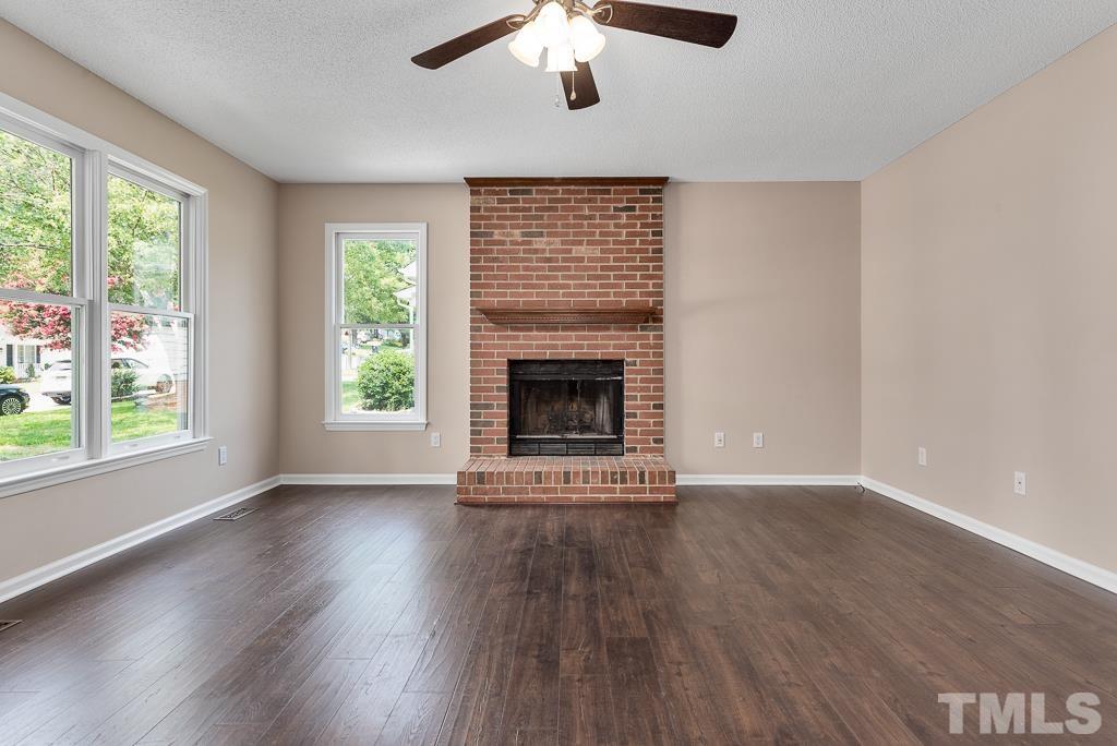 3308 Castlegate Drive Raleigh, NC 27616 - Photo 3 of 22 a view of an empty room with wooden floor fireplace and a window