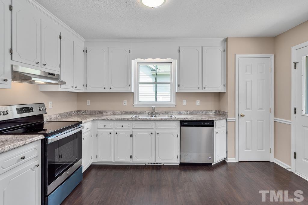 3308 Castlegate Drive Raleigh, NC 27616 - Photo 8 of 22 a kitchen with granite countertop white cabinets and a stove with wooden floor