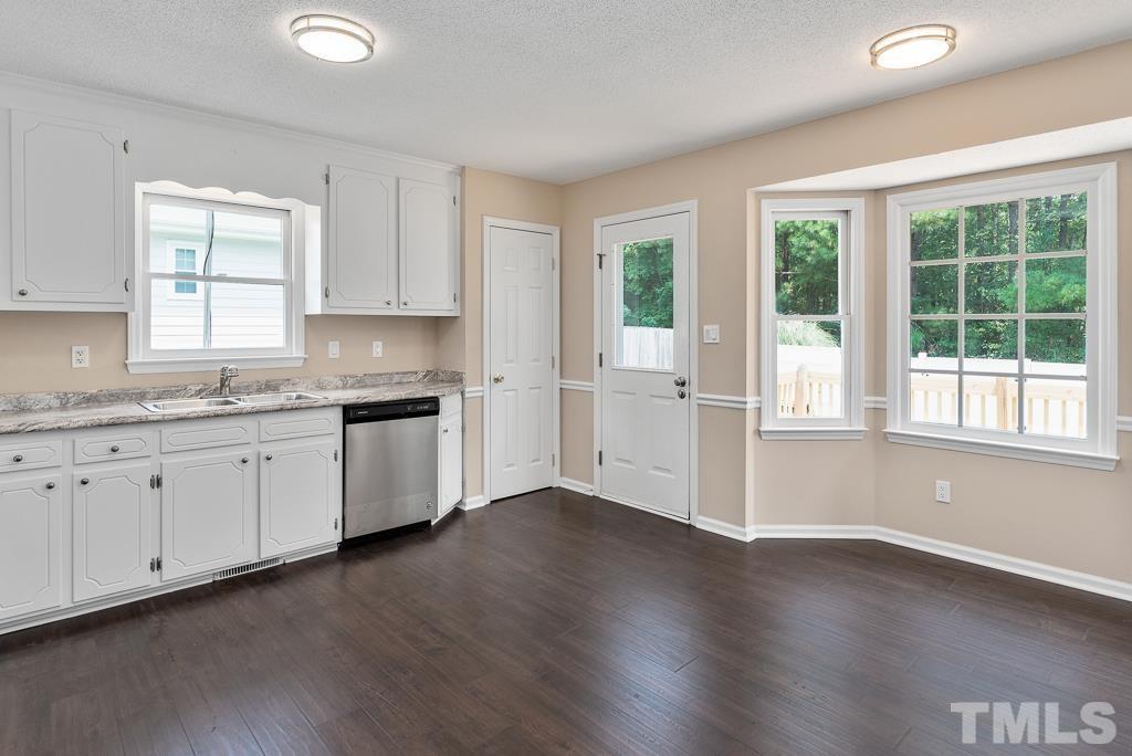 3308 Castlegate Drive Raleigh, NC 27616 - Photo 9 of 22 a kitchen with granite countertop white cabinets and wooden floors