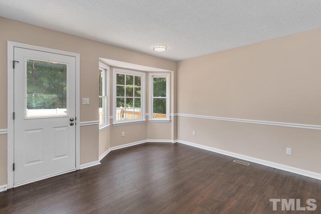 3308 Castlegate Drive Raleigh, NC 27616 - Photo 10 of 22 a view of an empty room with wooden floor and windows