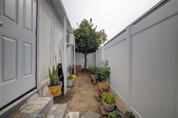 a view of a backyard with potted plants and wooden fence