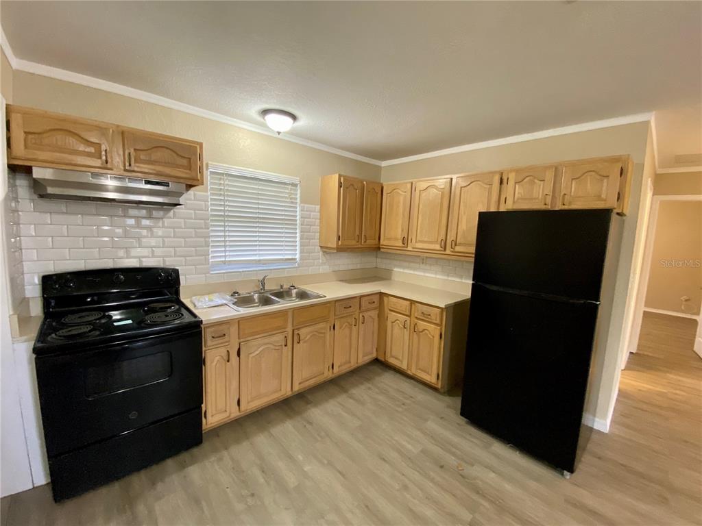38313 Tucker Road Zephyrhills, FL 33542 - Photo 13 of 46 a kitchen with a stove a refrigerator and a sink
