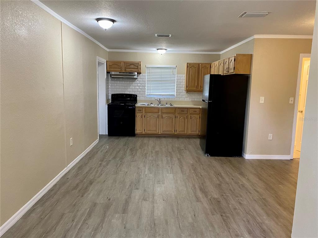 38313 Tucker Road Zephyrhills, FL 33542 - Photo 14 of 46 a kitchen with a refrigerator and a stove top oven