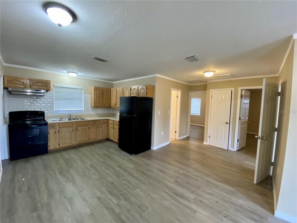 38313 Tucker Road Zephyrhills, FL 33542 - Photo 15 of 46 a view of kitchen with refrigerator cabinets and wooden floor