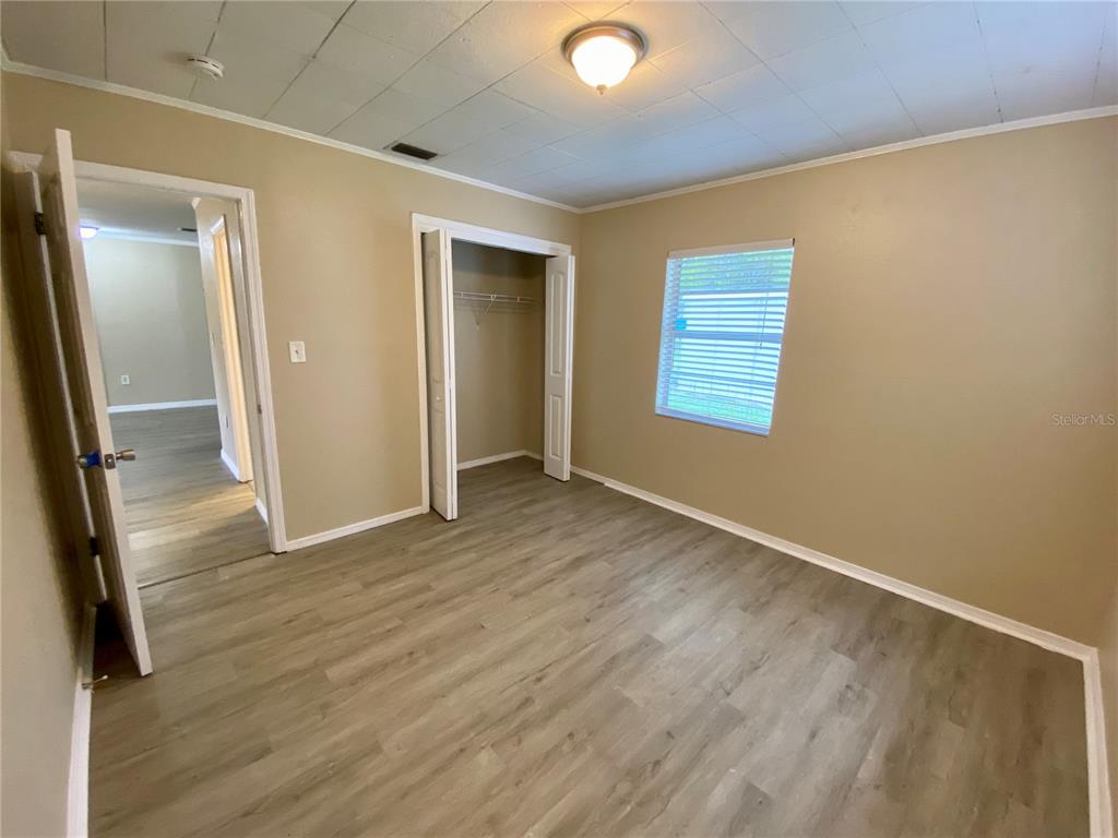 38313 Tucker Road Zephyrhills, FL 33542 - Photo 17 of 46 an empty room with wooden floor and a ceiling fan