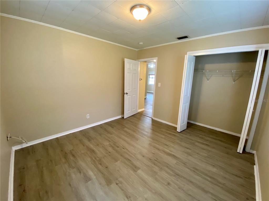 38313 Tucker Road Zephyrhills, FL 33542 - Photo 18 of 46 a view of an empty room with wooden floor and closet