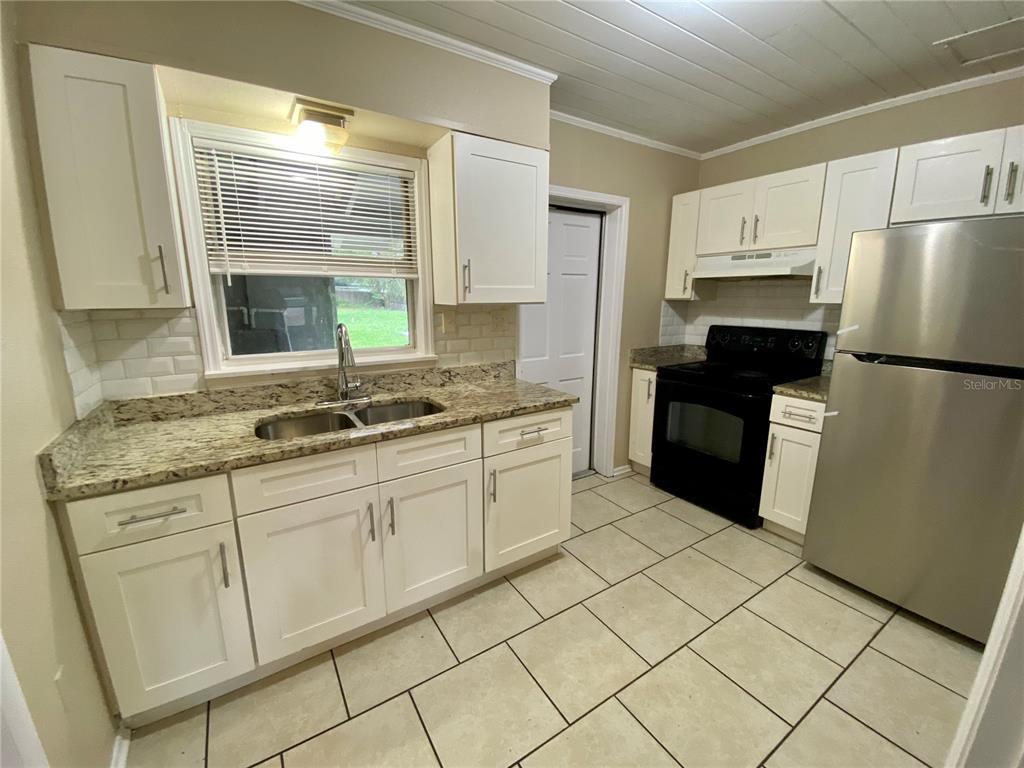38313 Tucker Road Zephyrhills, FL 33542 - Photo 4 of 46 a kitchen with white cabinets a refrigerator and a sink