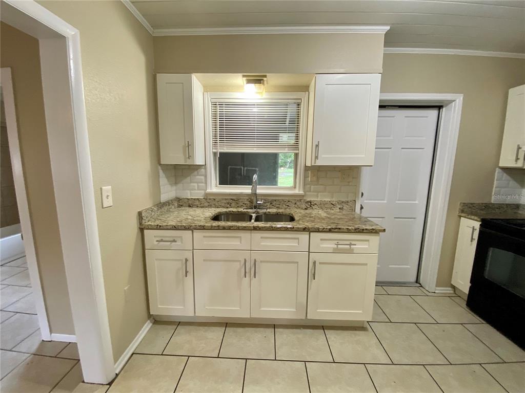 38313 Tucker Road Zephyrhills, FL 33542 - Photo 5 of 46 a kitchen with granite countertop a sink a stove a refrigerator and cabinets