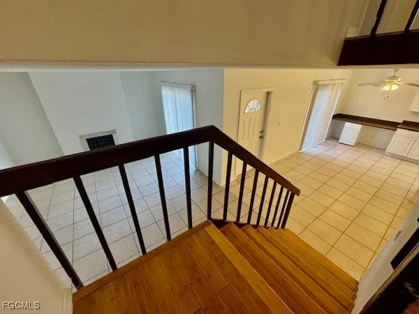 a view of an empty room with wooden floor and windows