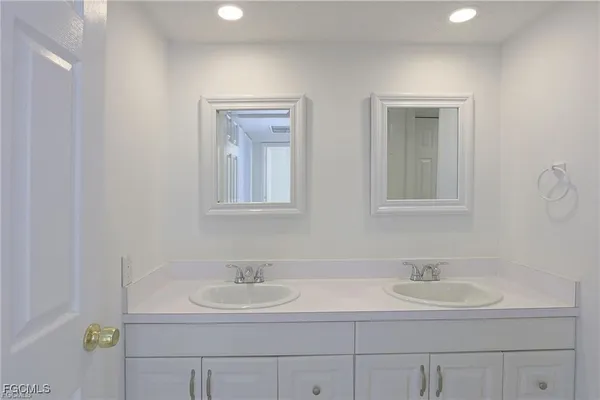 a bathroom with double sink and a mirror