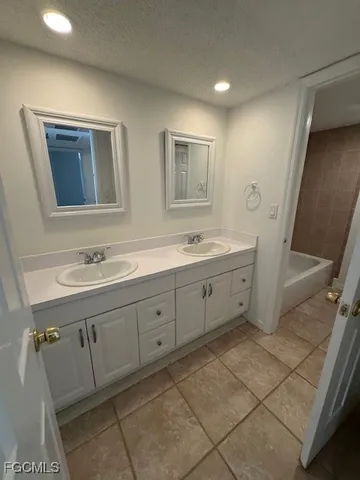 a spacious bathroom with a double vanity sink a mirror and a shower