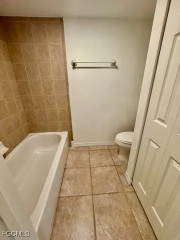 a bathroom with a granite countertop bathtub and toilet