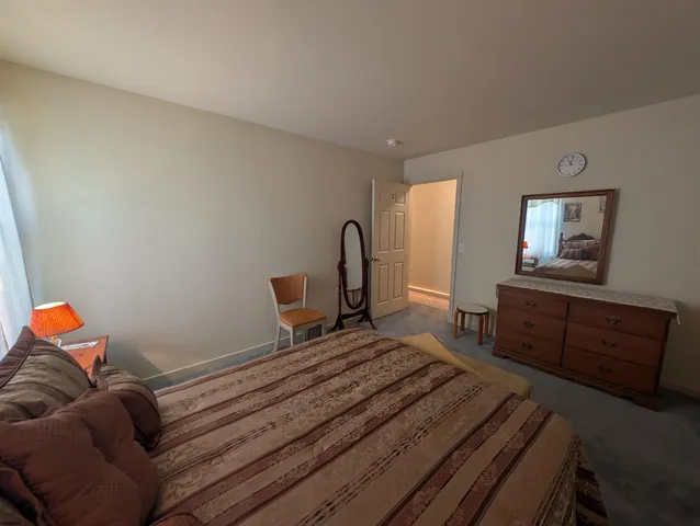 a bedroom with a bed couch and a window
