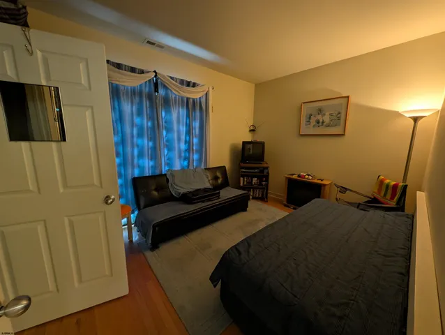a living room with furniture and a air conditioner vent