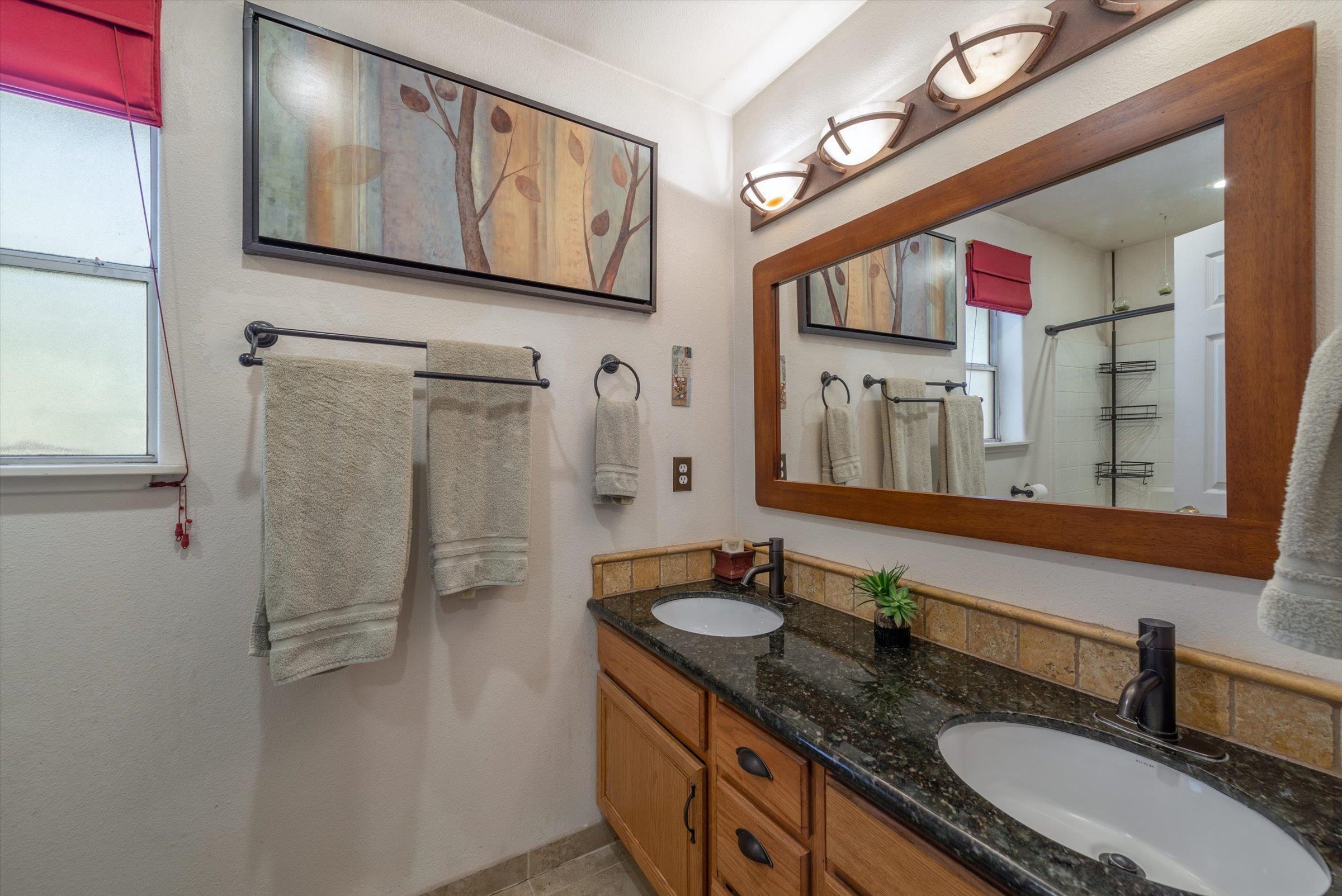 12860 Dulzura Street Truckee, CA 96161 - Photo 10 of 21 a bathroom with a granite countertop sink mirror and a shower