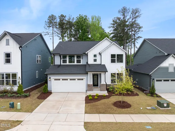 a front view of a house with yard garage and outdoor seating