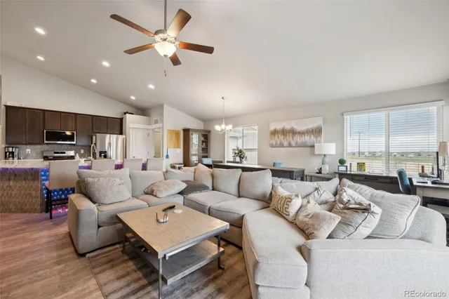 a living room with furniture kitchen view and a large window