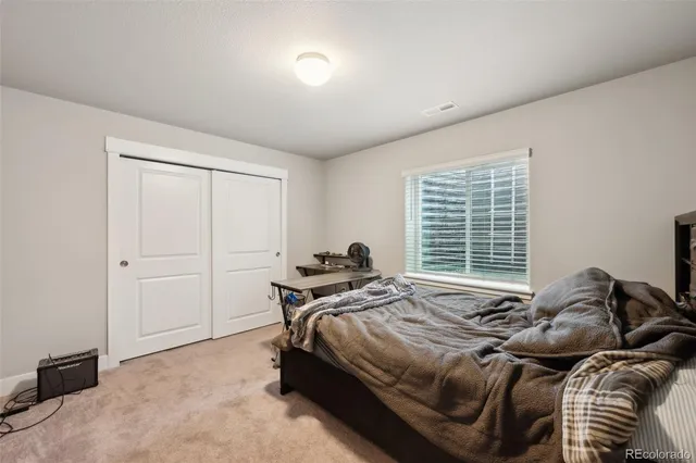 a bed sitting in a bedroom next to a window and dresser