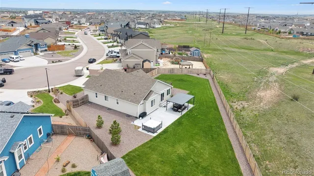 an aerial view of a house with a garden and lake view