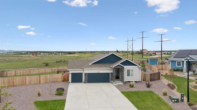 a front view of a house with a garden and lake view