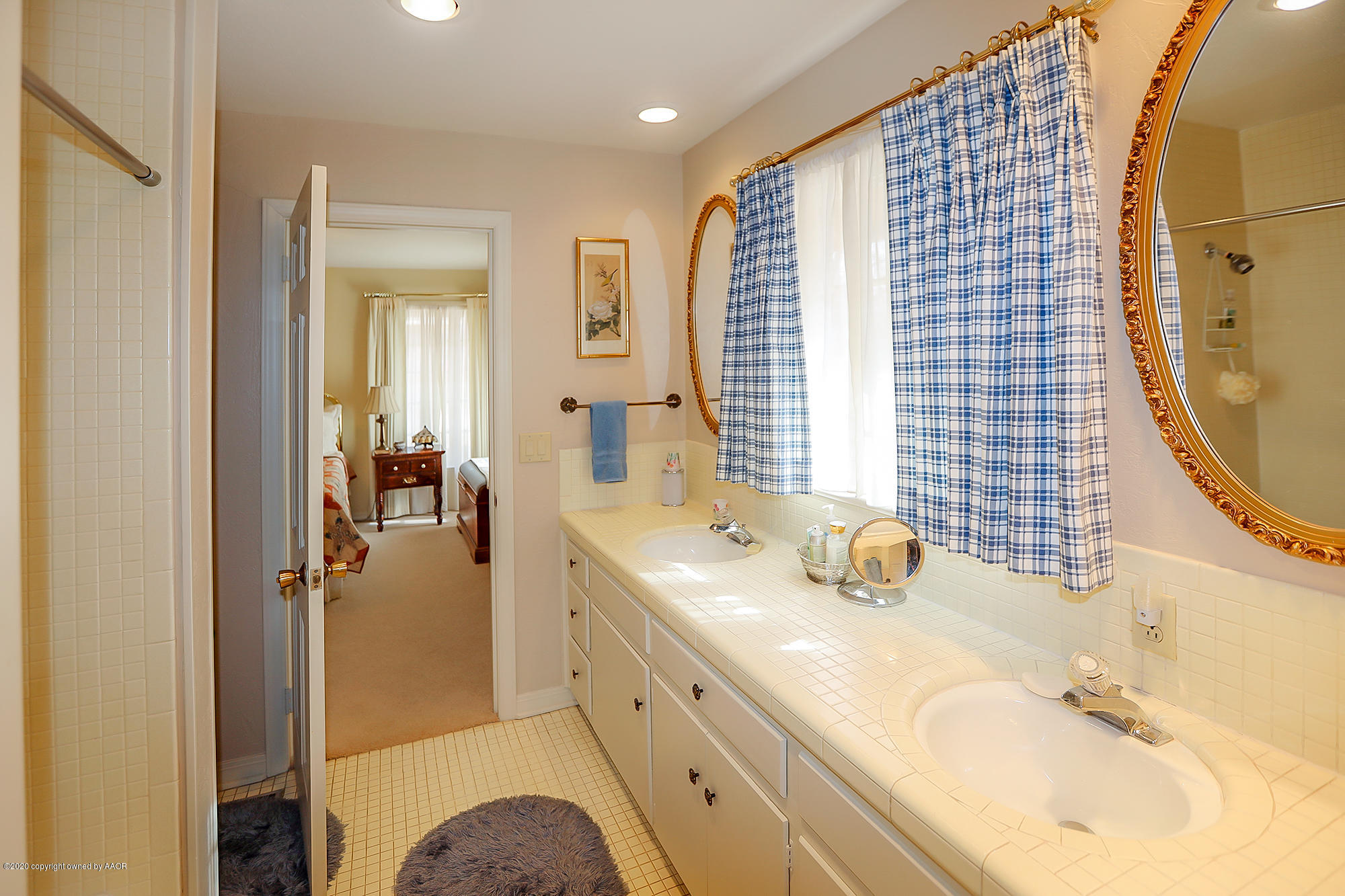 6908 Calumet Road Amarillo, TX 79106 - Photo 26 of 40 a en suite bathroom with a double vanity sink a mirror and a shower