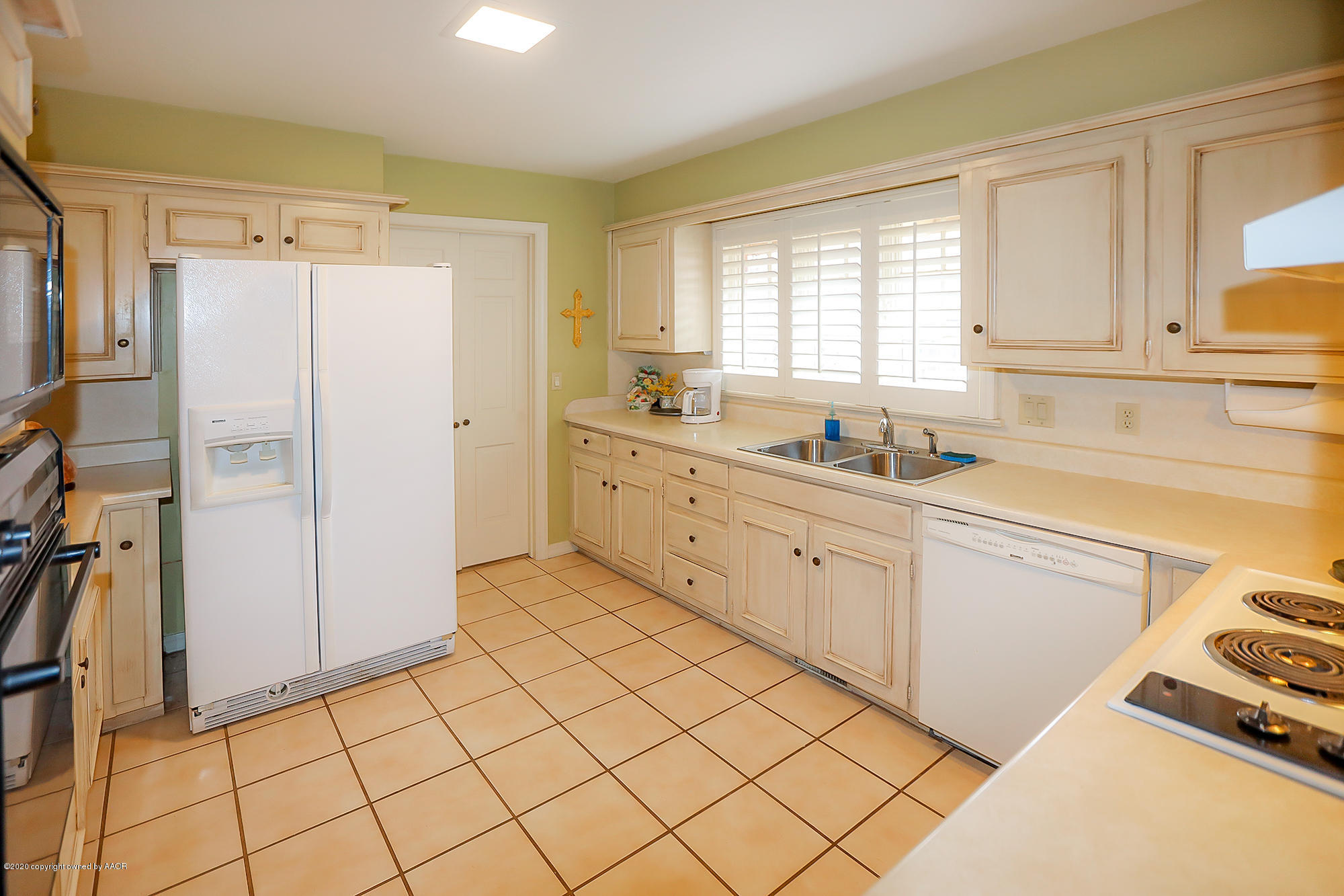 6908 Calumet Road Amarillo, TX 79106 - Photo 7 of 40 a kitchen with a refrigerator a sink and cabinets