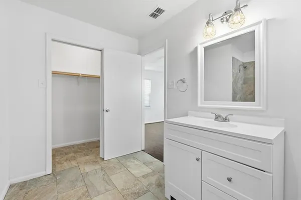 a bathroom with a sink vanity and mirror