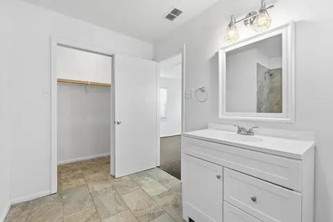 a bathroom with a sink vanity and mirror