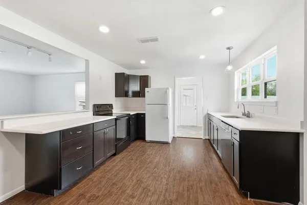 a large kitchen with stainless steel appliances sink a microwave and cabinets