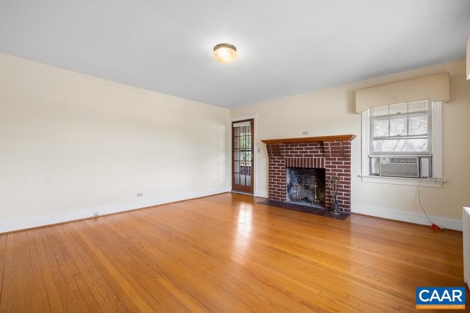 1201 Avon Street Charlottesville, VA 22902 - Photo 6 of 71 a view of an empty room with wooden floor fireplace and a window