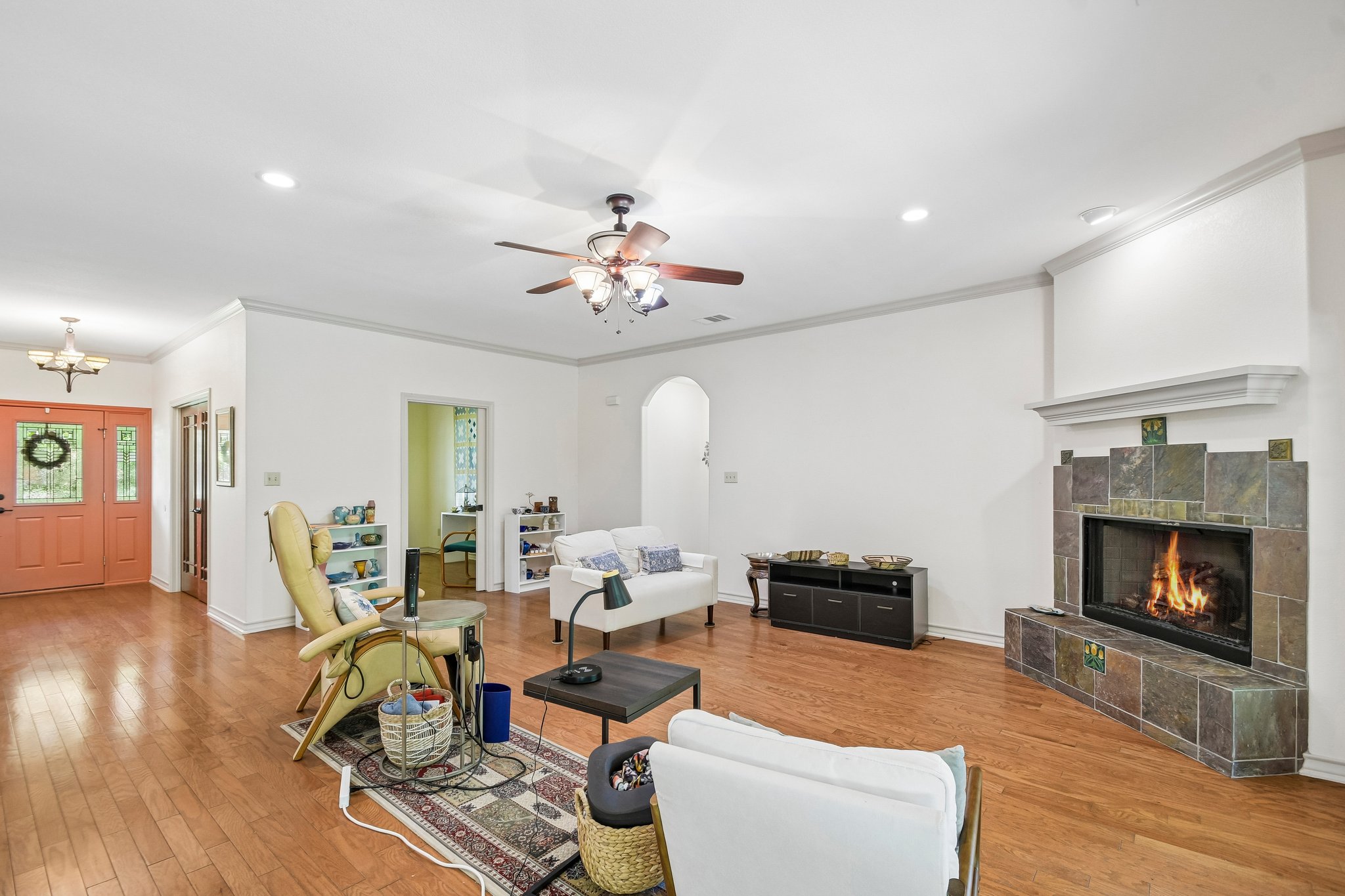 307 West 4th Street Elgin, TX 78621 - Photo 8 of 40 Expansive living space featuring wood-finish flooring, a tiled fireplace with mantel, recessed lighting, and a ceiling fan