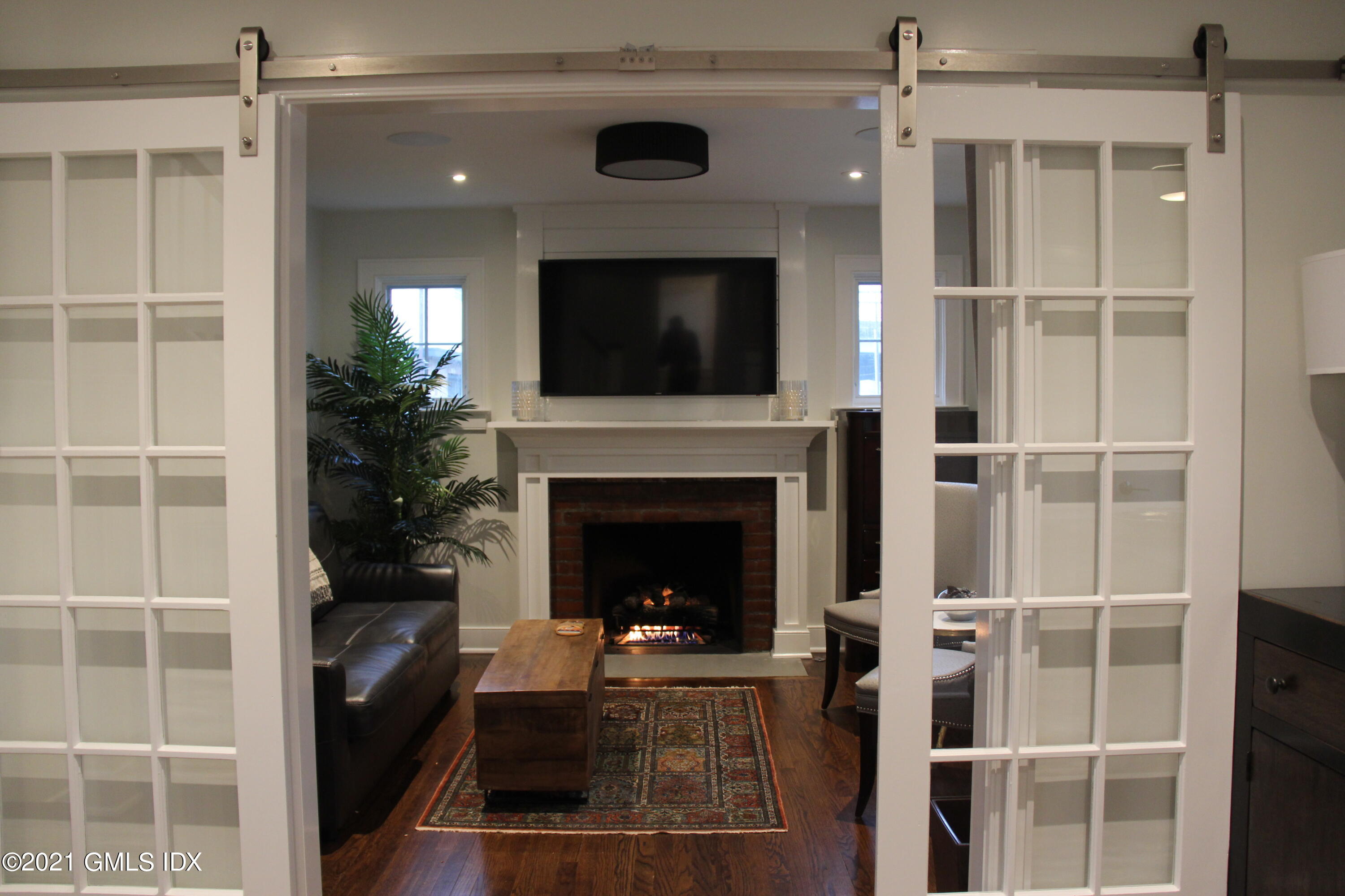 40 Strickland Road Cos Cob, CT 06807 - Photo 8 of 22 a living room with a fireplace and a flat screen tv
