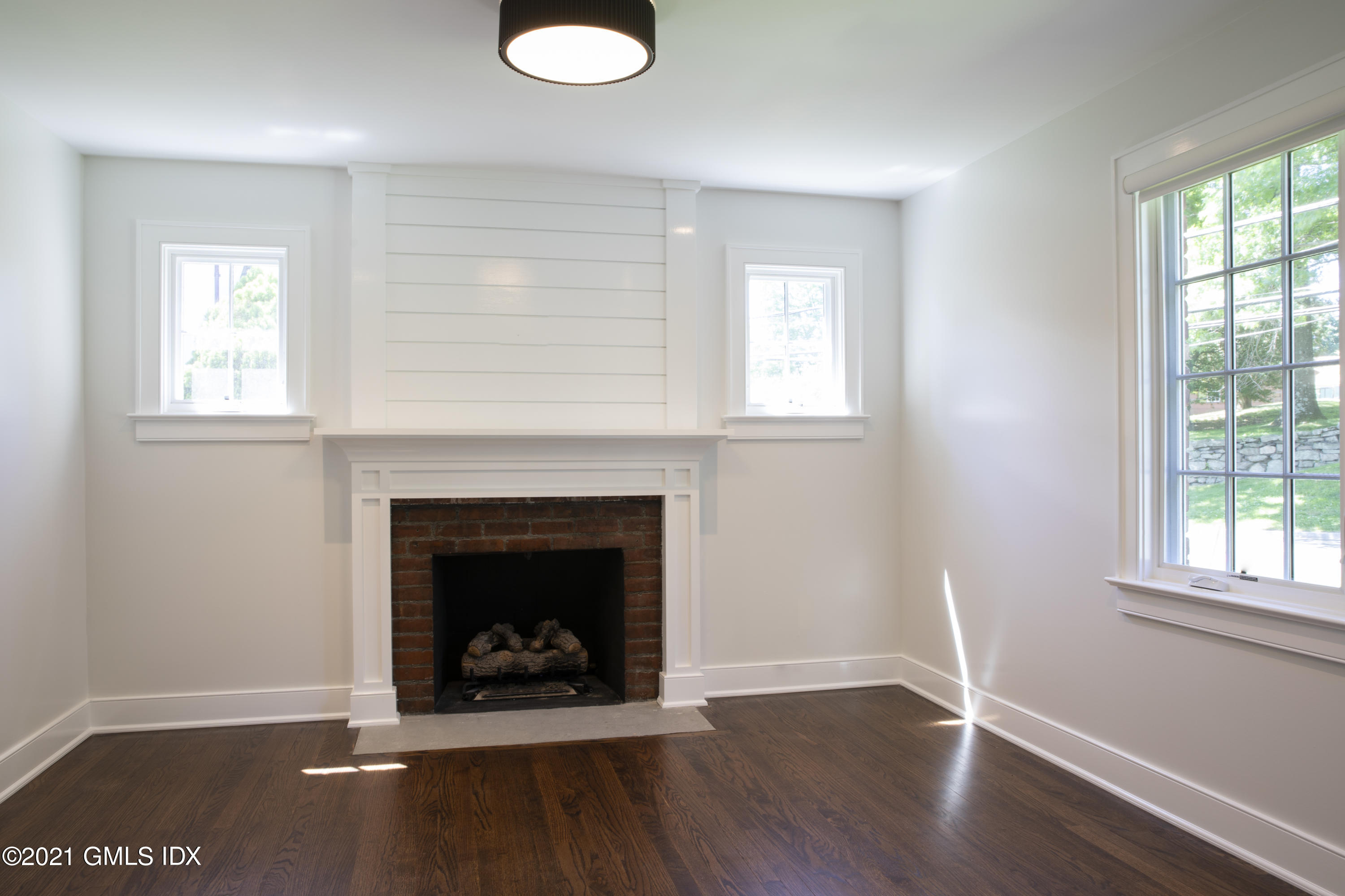 40 Strickland Road Cos Cob, CT 06807 - Photo 9 of 22 an empty room with wooden floor fireplace and windows