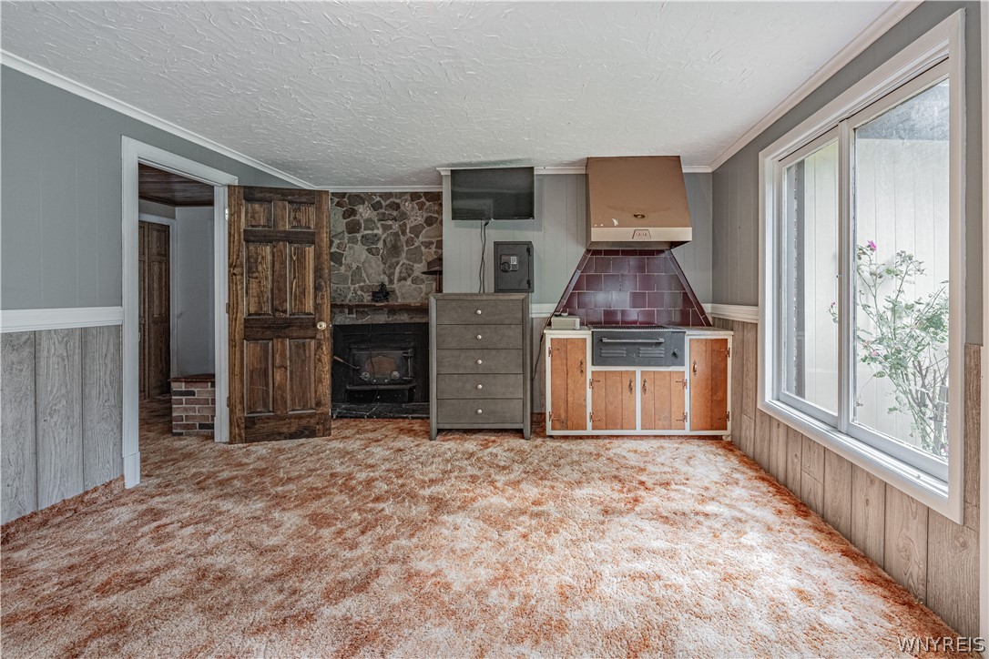 6775 Bear Ridge Road Pendleton, NY 14094 - Photo 30 of 48 A stone fireplace accents this versatile room with wood paneling and large windows.