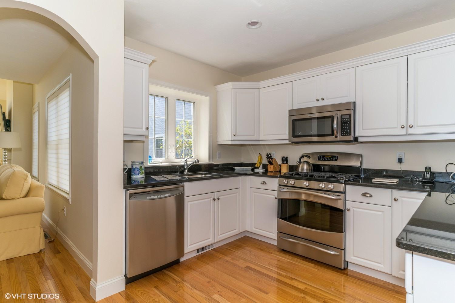 68 Brookside Road Bourne, MA 02532 - Photo 5 of 15 a kitchen with stainless steel appliances granite countertop a stove top oven a sink dishwasher and white cabinets with wooden floor