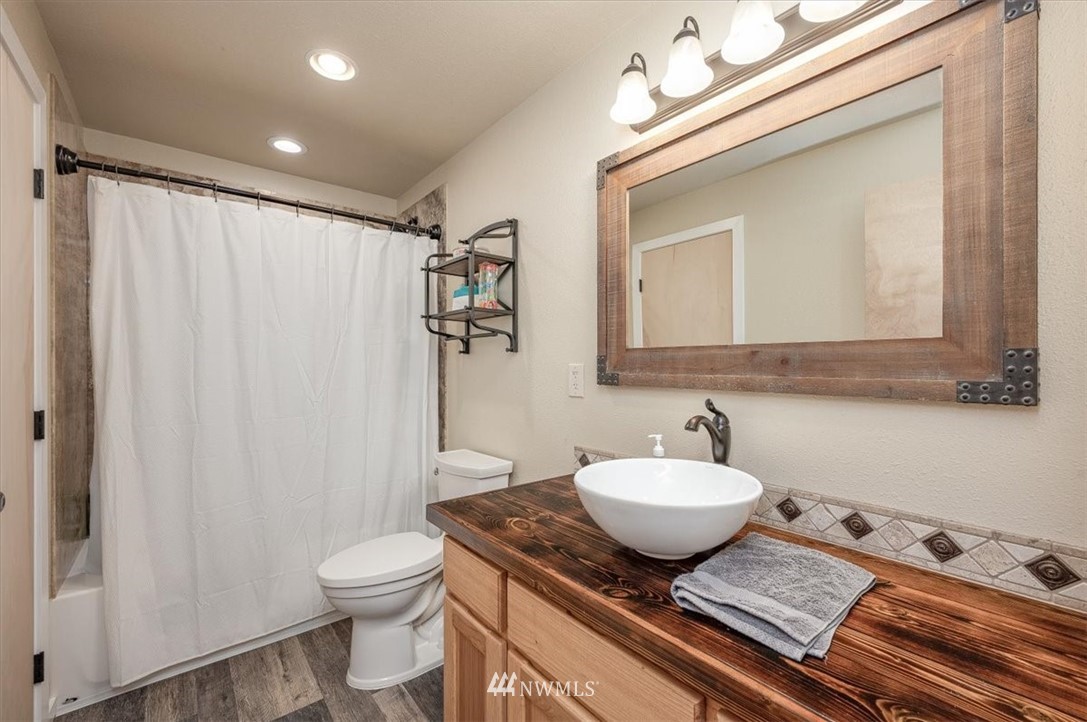 5942 Longdin Road Ferndale, WA 98248 - Photo 4 of 30 a bathroom with a granite countertop sink toilet and shower