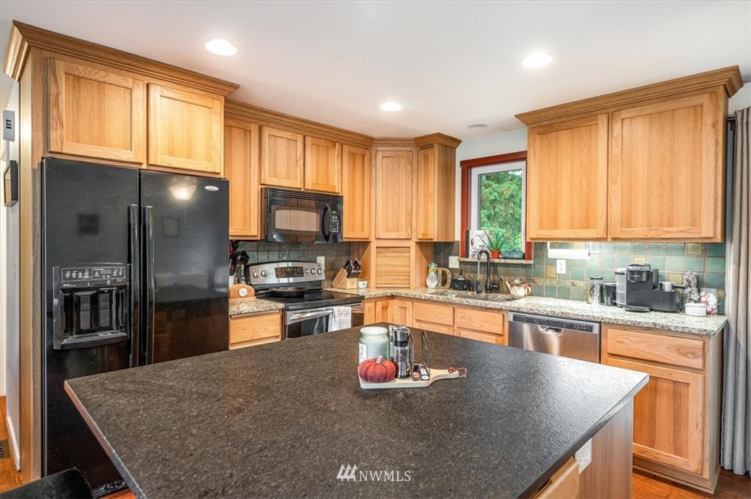 5942 Longdin Road Ferndale, WA 98248 - Photo 8 of 30 a kitchen with stainless steel appliances granite countertop a refrigerator a stove top oven a sink and dishwasher
