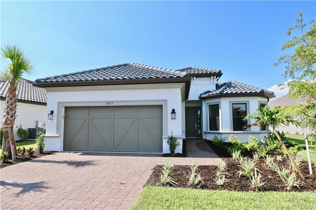 8437 Rosa Court Naples, FL 34114 - Photo 1 of 32 a front view of a house with a yard and garage