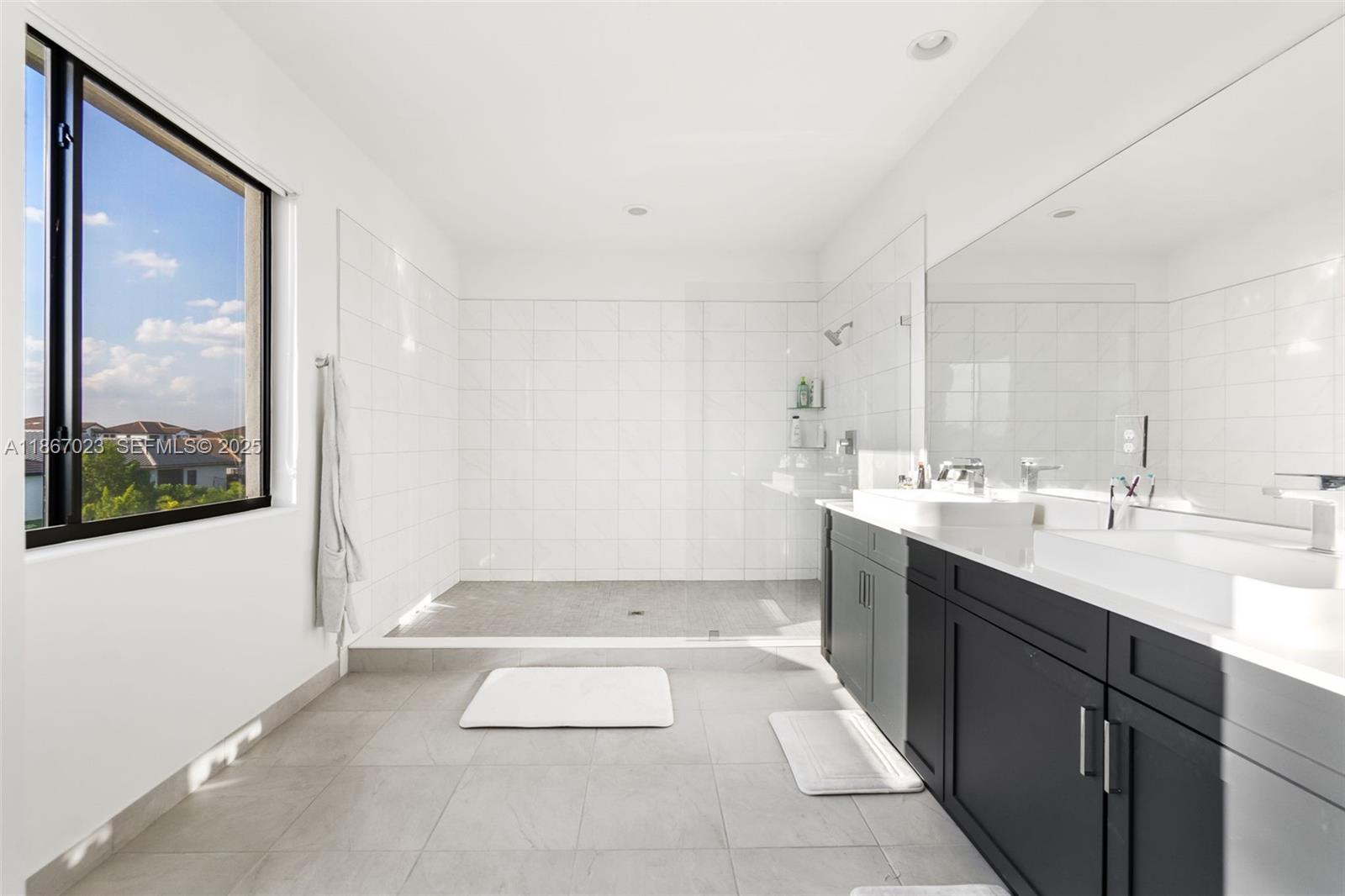 4948 Gambero Way Ave Maria, FL 34142 - Photo 16 of 28 a spacious bathroom with a double vanity sink a mirror and a bathtub